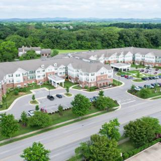 Aerial view of a suburban residential complex surrounded by trees and roads.