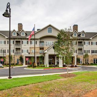 A large residential building with an American flag at the entrance.