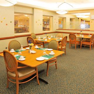 A well-lit dining area with neatly arranged tables and chairs, ready for guests.