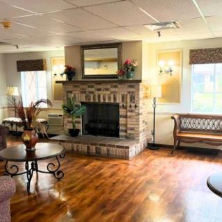 A cozy living room with a central fireplace and elegant wood flooring.