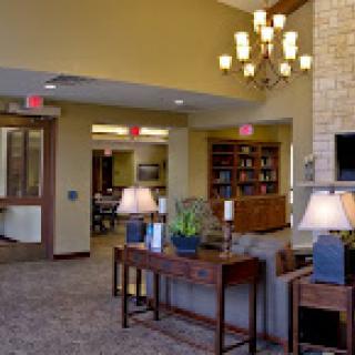 A cozy lobby featuring elegant lighting, comfortable seating, and a well-stocked bookshelf.