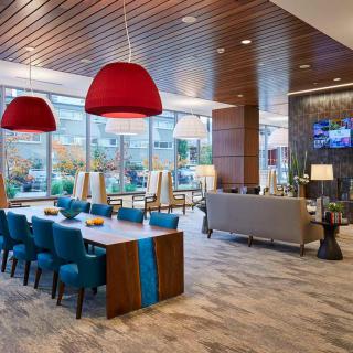A modern lobby area featuring comfortable seating, stylish lighting fixtures, and large windows.