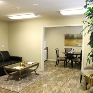 A cozy living and dining space featuring modern furniture, artwork on the wall, and indoor plants.