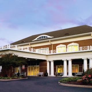 A charming hotel entrance showcasing classic architectural details and inviting landscaping.