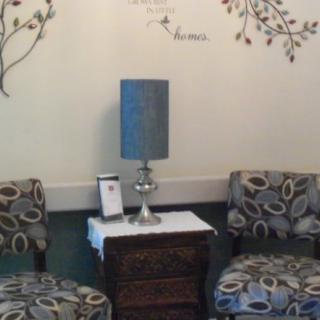 A cozy seating area with patterned chairs, a side table, and a decorative lamp, complemented by wall art.