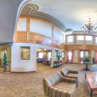 A spacious lobby with modern furniture, a large chandelier, and elegant decor.