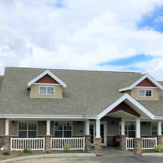 A cozy residential house with a spacious porch and a cloudy sky in the background.