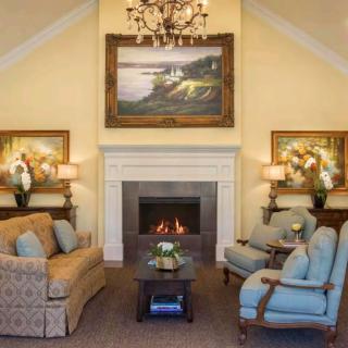 A cozy living room with a fireplace, elegant furniture, and decorative artwork.