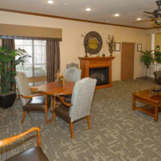 A cozy living room with a fireplace, seating area, and table.