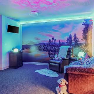 A cozy and modern room with neon lights, vibrant wall art, and comfortable seating.