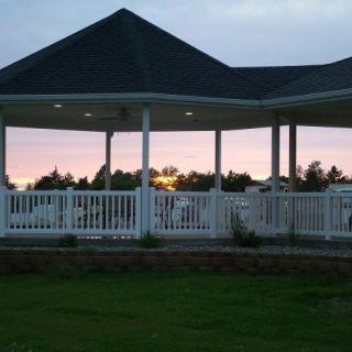 A gazebo silhouetted against a colorful sunset sky.