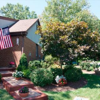 A suburban house with a well-maintained garden and an American flag.
