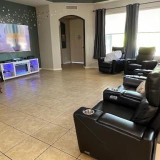 A cozy and modern living room featuring reclining chairs and a TV setup.