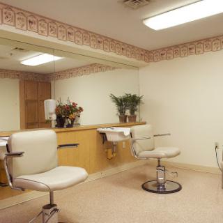 A tidy and organized salon space featuring styling chairs and a large mirror.