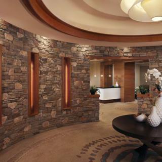 A stylish reception area with stone walls, elegant decor, and modern lighting.