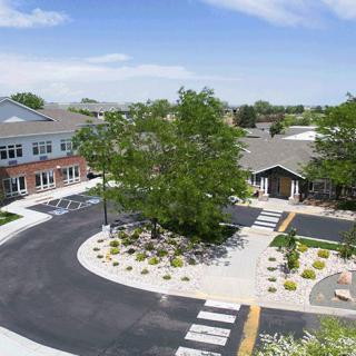 Aerial view of a landscaped area with buildings, trees, and a road.