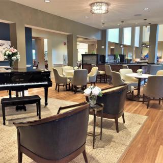 A modern and luxurious lounge area featuring a grand piano, comfortable seating, and elegant decor.