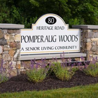 Entrance sign for Pomperaug Woods, a senior living community located on Heritage Road.