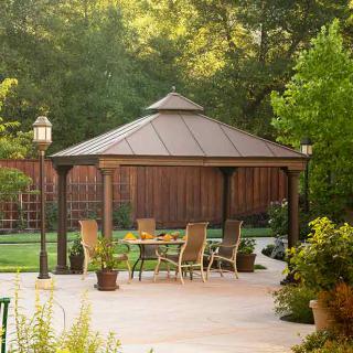 A serene backyard scene featuring a gazebo with patio furniture surrounded by lush greenery.