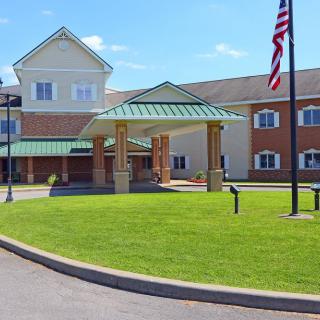 A large building with a welcoming entrance and an American flag flying nearby.
