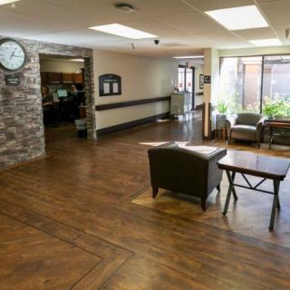 A spacious lobby with seating area and a clock on the wall.