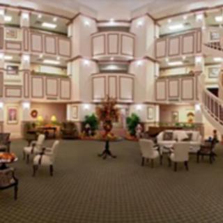 A spacious hotel lobby with elegant furniture and ornate chandeliers.