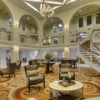 Elegant and spacious hotel lobby with luxurious decor and a grand staircase.