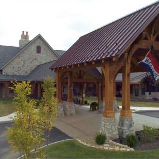 A modern building entrance with wooden beams and a flag hanging.