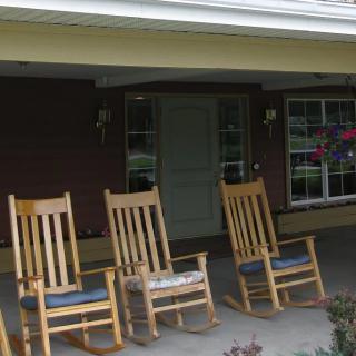 A cozy front porch with wooden rocking chairs invites relaxation.