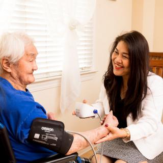 A healthcare professional checking the blood pressure of an elderly patient.