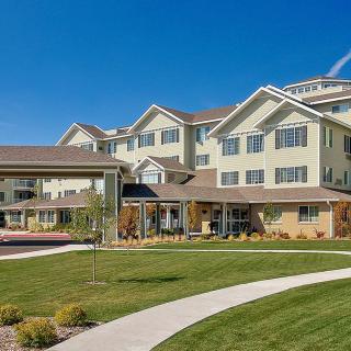 A modern residential building with well-maintained landscaping and a clear blue sky.