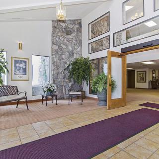 A spacious lobby area with stylish decor, featuring seating and greenery.