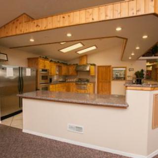 A spacious modern kitchen with wood cabinets and stainless steel appliances.