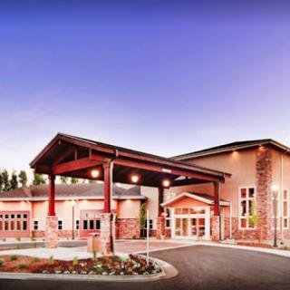 A modern architectural building featuring a welcoming entrance and landscaped surroundings.
