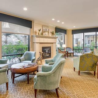 A cozy and bright living room with comfortable seating, a fireplace, and large windows.