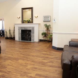 A spacious and inviting living room featuring a fireplace, comfortable seating, and decorative plants.
