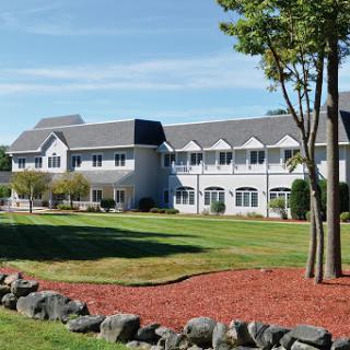 A serene hotel surrounded by greenery and a clear blue sky.