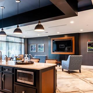A modern open-plan kitchen and living area with stylish lighting and comfortable seating.