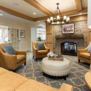A cozy living room with a fireplace, comfortable seating, and elegant decor.