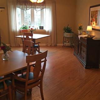 A cozy dining room with wooden furniture and a large window.