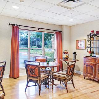 A cozy dining area with wooden furniture and a large window.