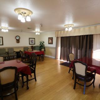 A cozy dining room setting with tables set for meals, featuring comfortable seating and warm lighting.
