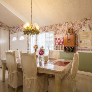 A cozy dining room with elegant furniture and floral wallpaper.