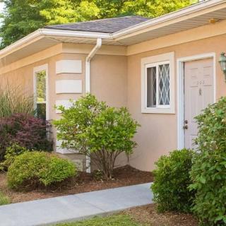 A charming residential house with a well-maintained garden and pathway leading to the front door.