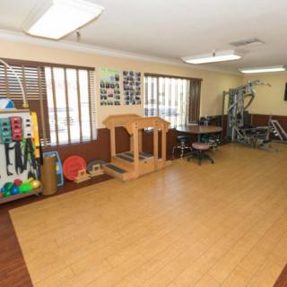 A well-equipped therapy room with various rehabilitation and exercise equipment.