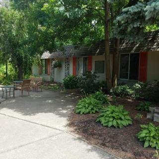 A charming house surrounded by lush greenery and landscaped gardens.