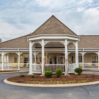 A charming building with a gazebo-style entrance and well-maintained landscaping.