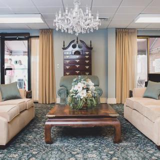 A well-appointed living room featuring elegant furniture, a chandelier, and tasteful decor.