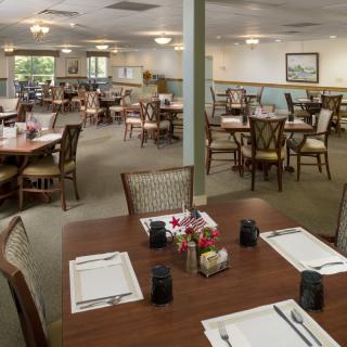 An empty dining area with neatly arranged tables and chairs, ready for guests.