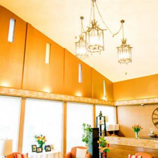 A warmly lit restaurant interior with chandeliers and dining tables.